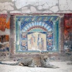 A leopard standing in a frescoed room of the House of Neptune and Amphitrite, Herculaneum.