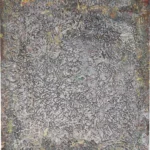 Dense field of fine cracks and scrapes in grey, ochre and purple over a darker layer.