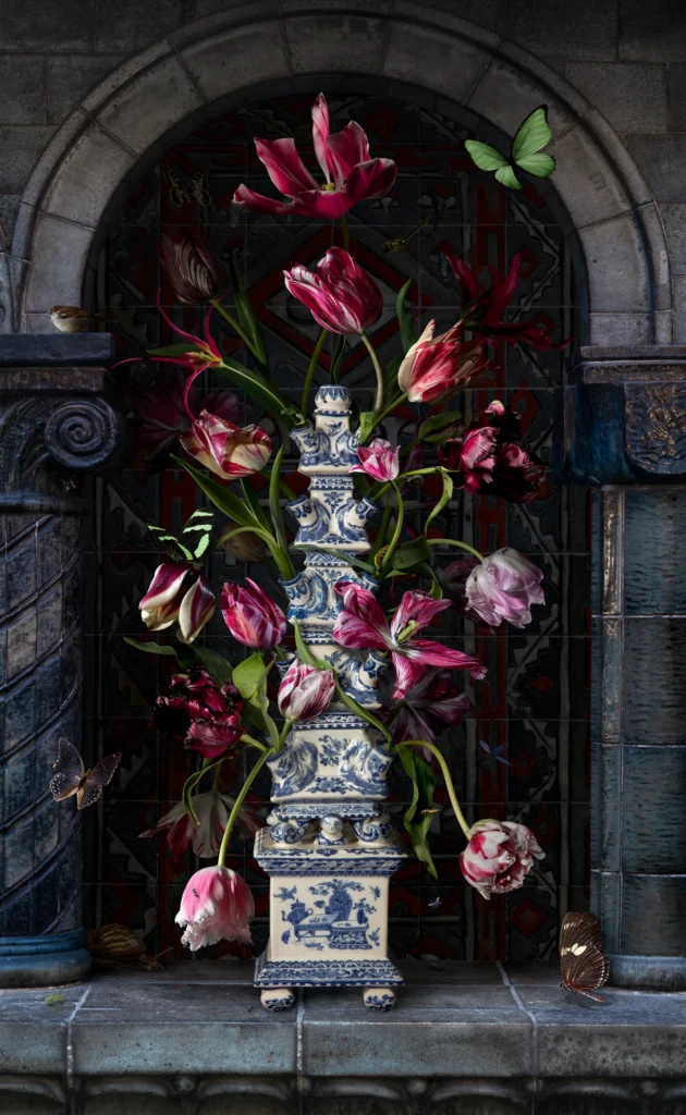 Tulips in a Delft blue flower pyramid set in a dark stone niche.