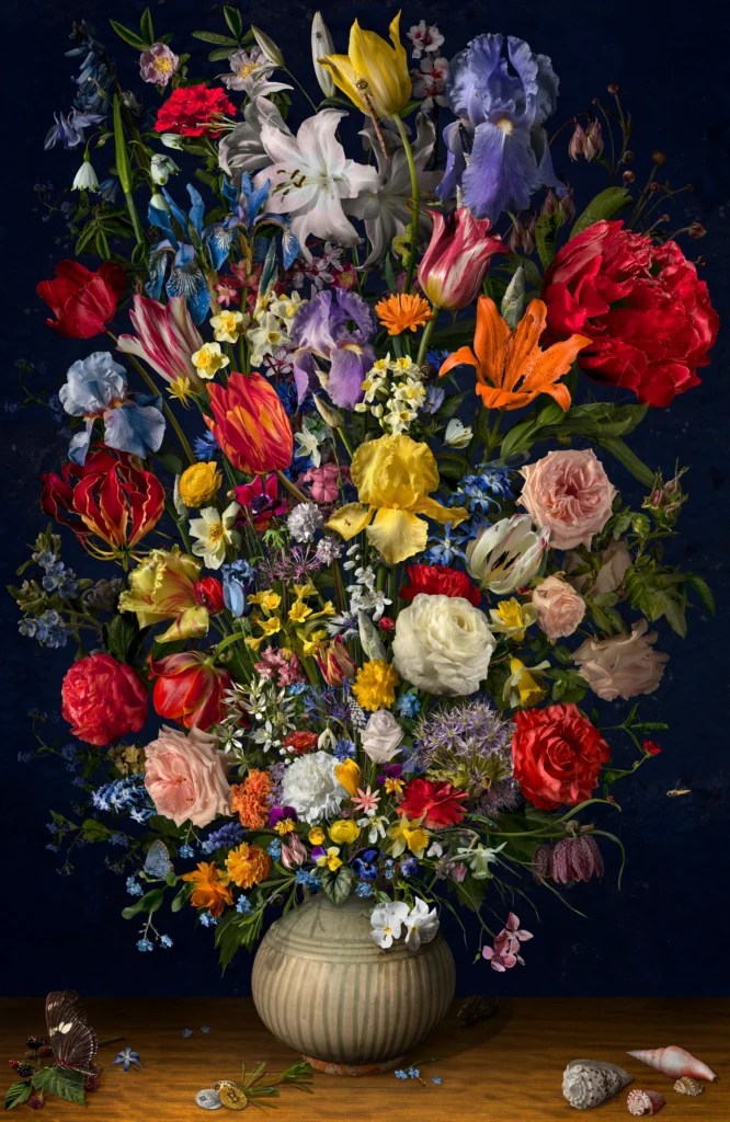 A dense bouquet of tulips, roses, iris and lilies in a stoneware vase against a dark blue ground.