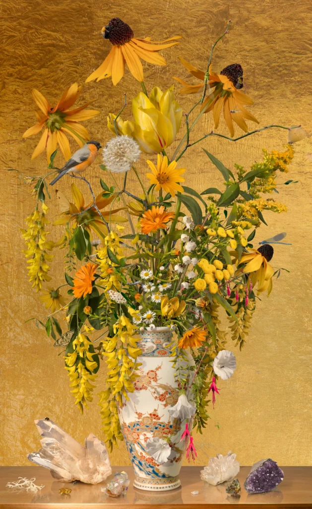 Yellow rudbeckia, laburnum and marigolds in a Chinese-style vase against a gold-leaf ground, with rock crystals on the ledge.