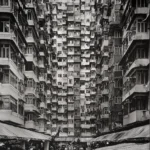 A narrow courtyard between tall apartment façades of stacked balconies, seen from street level with market stalls below.